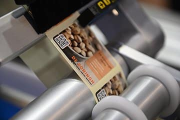 Aanbrengen van label op een verpakking met onze etiketteermachine van Altech